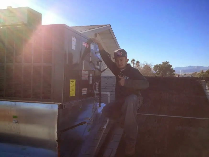HVAC technician performing AC Tune-Up on a rooftop unit in Finneytown